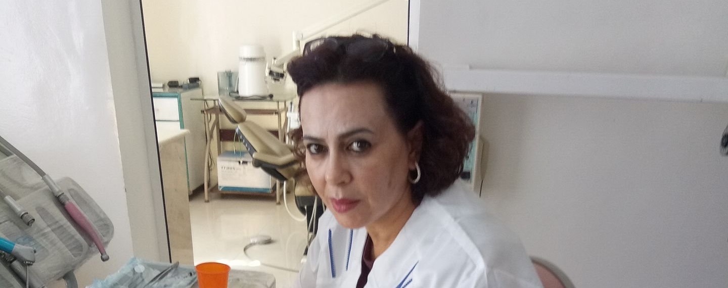 Praticienne en blouse blanche au fauteuil, une seconde salle de soins visible à l’arrière-plan